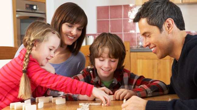 Family playing math game with dominoes
