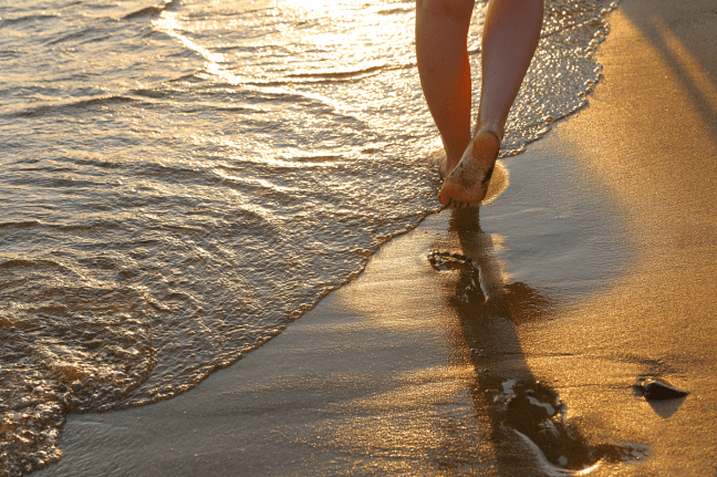 photo of child making footprints on the beach