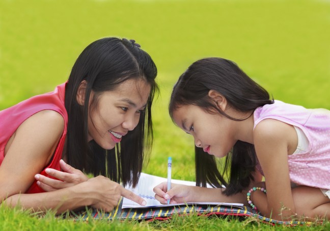 Mother and daughter doing homework outdoors