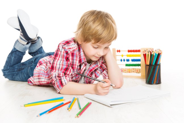 Young boy writing math expressions